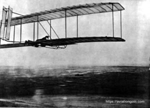 One of the successful glides made in October 1902 with the 1902 glider, camp buildings in distance